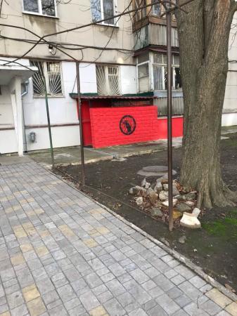 Вход с красными стенами, нарисована черная мышь. 